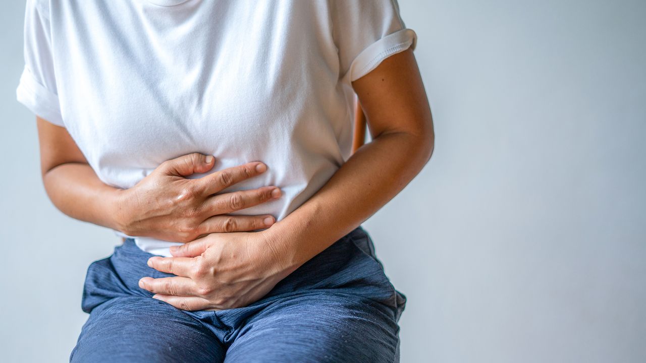 woman in pain holding onto tummy