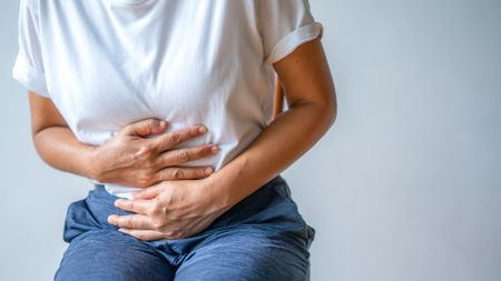 woman in pain holding onto tummy