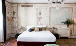 Bedroom featuring parquet flooring, chandelier, and period wallpaper