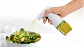 Oil Mist Sprayer spraying olive oil onto a salad