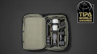 An organized camera bag displaying multiple lenses, a camera body, a drone, and batteries, set against a dark background