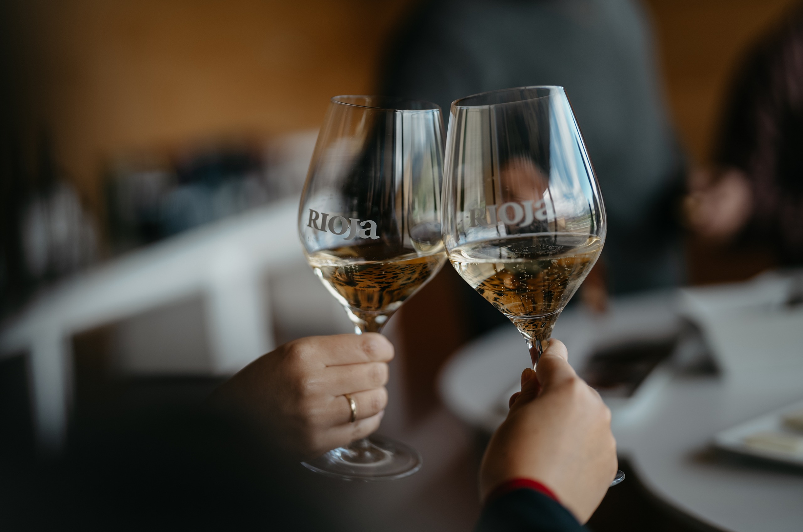 Two hands clinking glasses of sparkling wine together