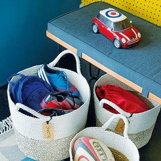 storage baskets with labels containing kids' sports kits and rugby ball