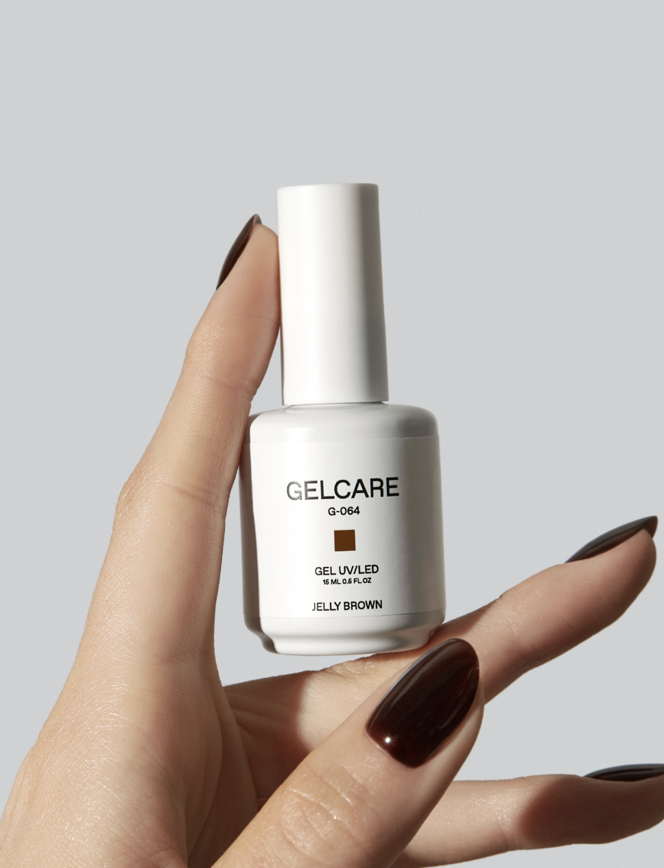 Woman wearing Gelcare Jelly Brown Nail Polish and holding bottle &amp;mdash; BestNailLooks