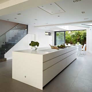 basement kitchen with white furniture and inhouse stairs