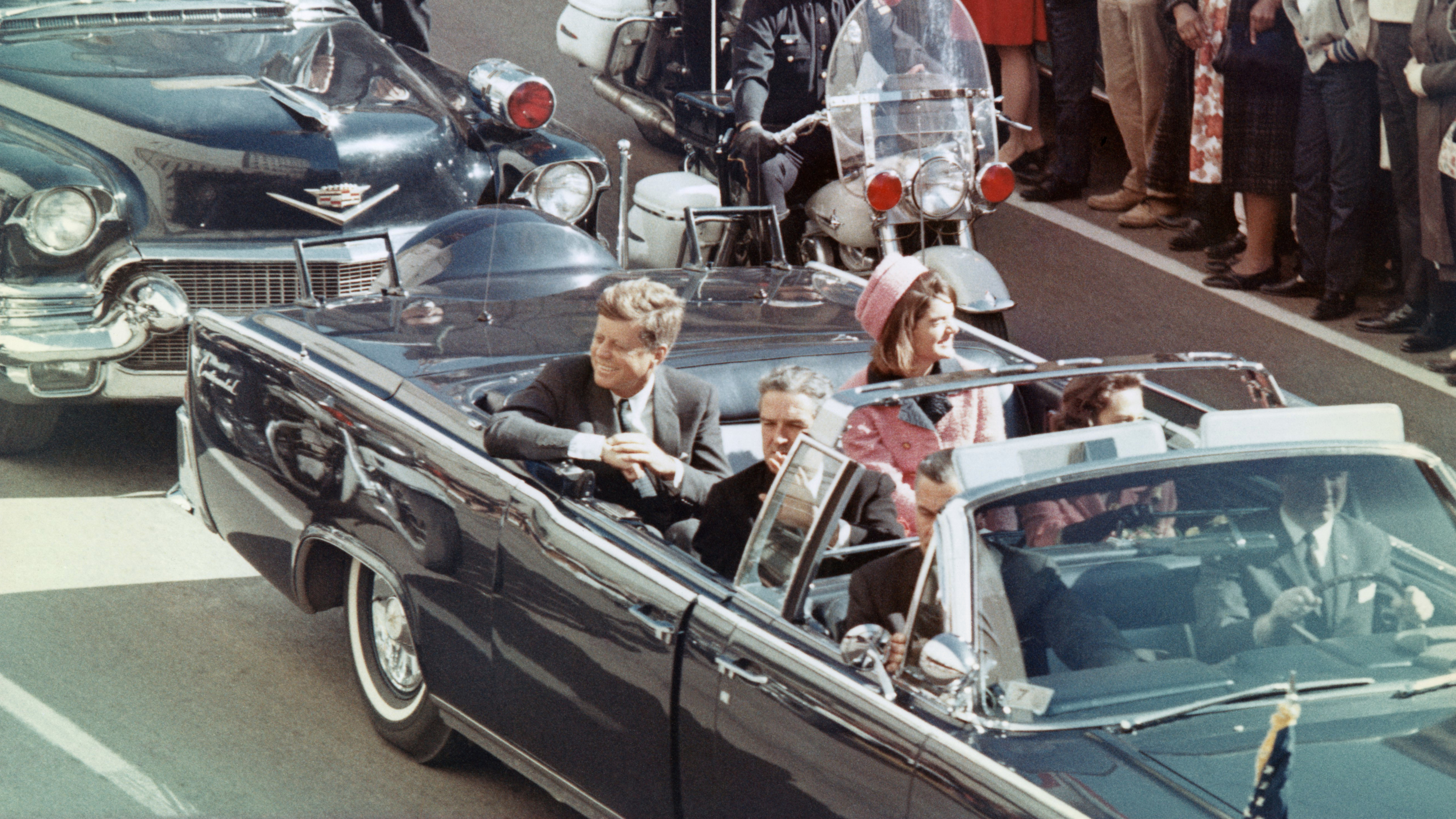 US President John F Kennedy, First Lady Jacqueline Kennedy, Texas Governor John Connally, and others smile at the crowds lining their motorcade route in Dallas, Texas, on November 22, 1963. Minutes later the President was assassinated as his car passed through Dealey Plaza.