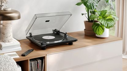 The Sharp RP-TT100 turntable on a light wooden unit with a lamp and a pot plant on either side of it