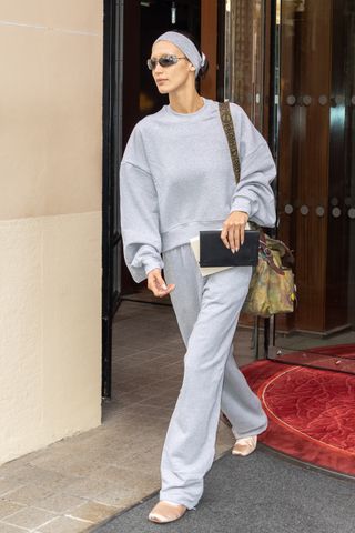 bella hadid wearing pink satin ballet flats and a gray sweatsuit