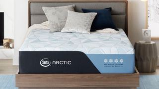 The Serta Arctic cooling mattress shown on a light brown wooden bed frame