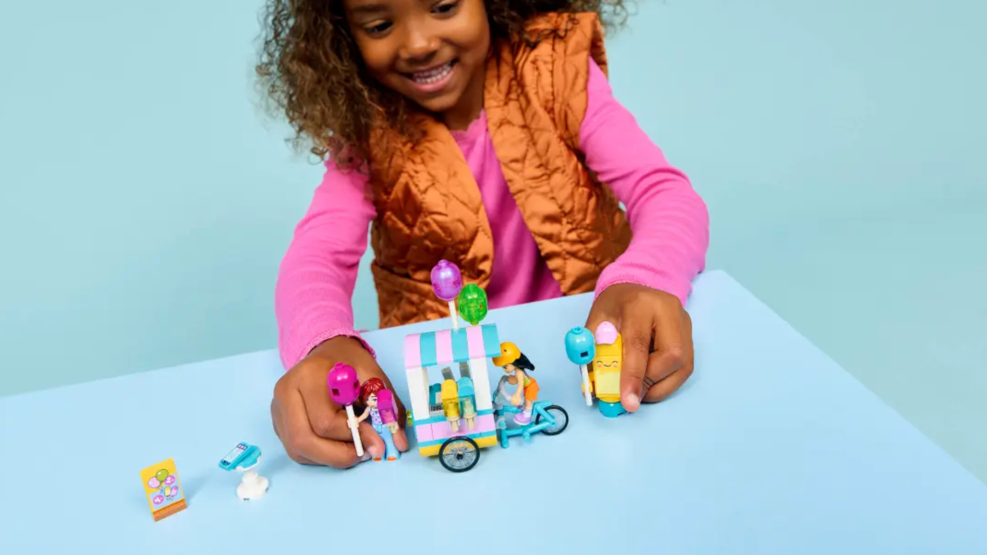 A child plays with a Lego ice cream stand set