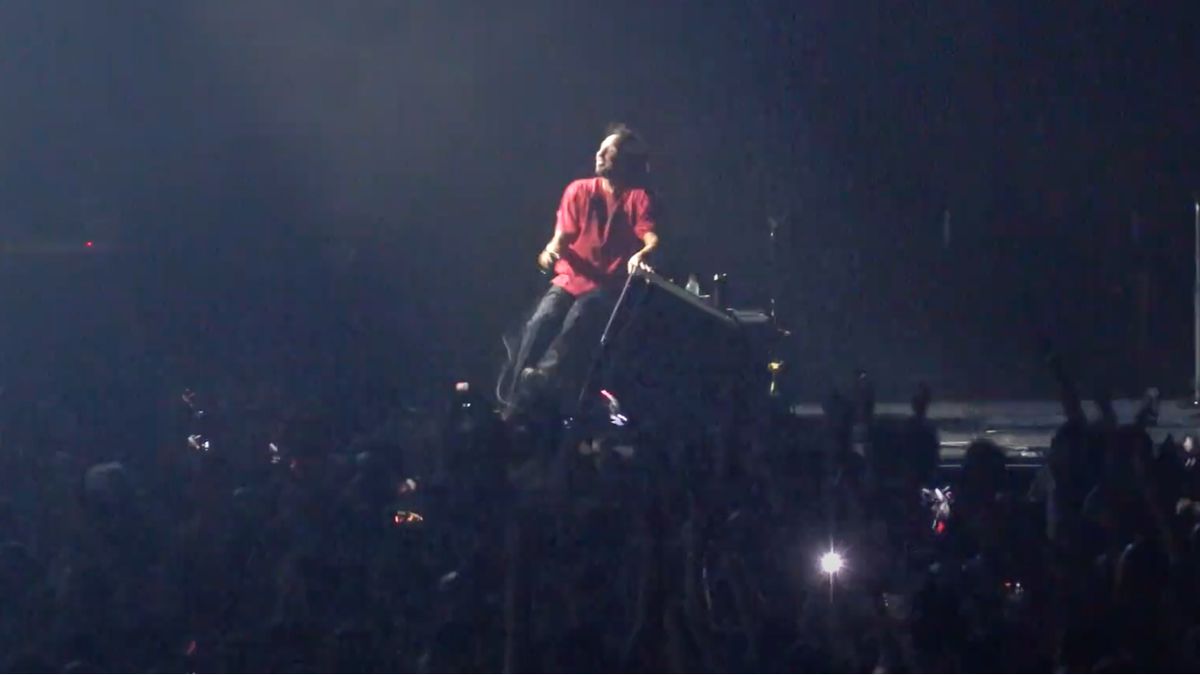 Zach De La Rocha sits on stage