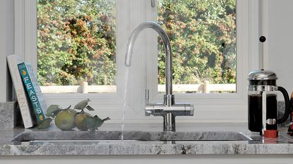 the QETTLE 4-in-1 Instant Boiling Water Tap (one of the best boiling water taps) in situ in a bright, modern kitchen