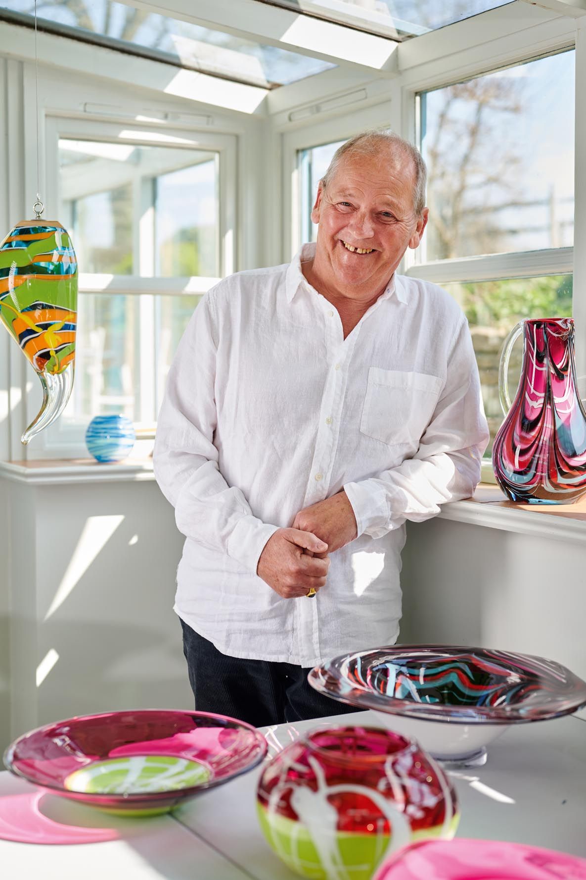 Glass-blower Nigel Calvert with his intense, sinuous pieces. Photography by Philip Sowels for Country Life.