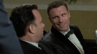 Howie Long looks at Tom Hanks with a mischievous smile in That Thing You Do!