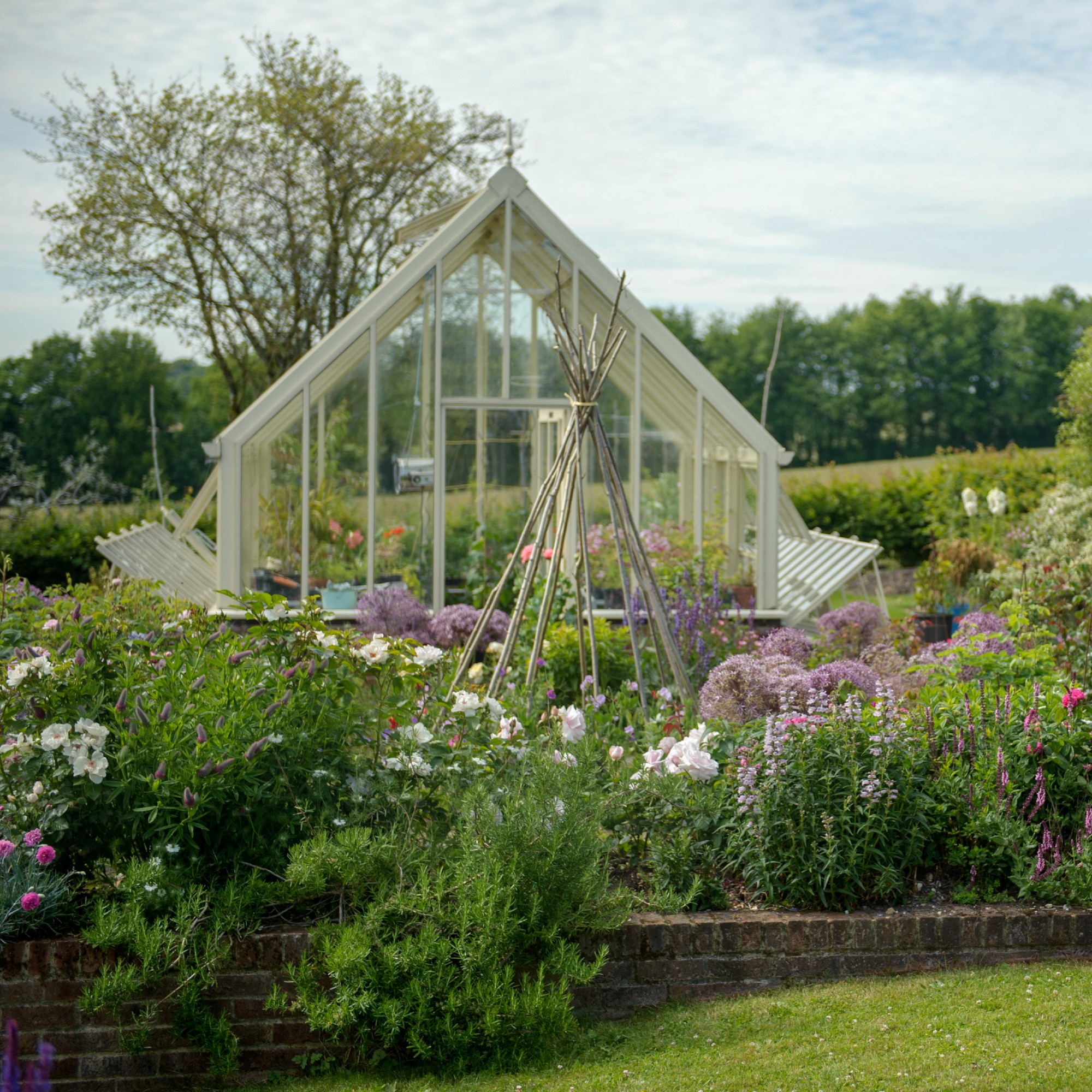 A blooming garden with a greenhouse