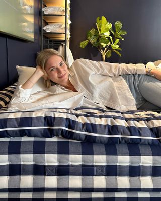Woman sitting on blue checkered mattress.