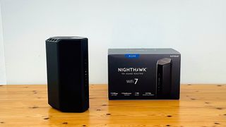 Netgear Nighthawk RS300 router sitting on a table next to its box