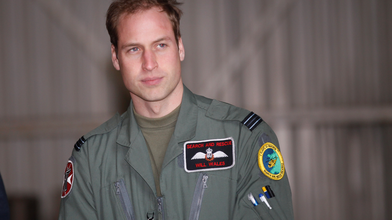 rince William waits for his grandmother Queen Elizabeth II to arrive for an offical visit to RAF Valley where Prince William is stationed as a search and rescue helicopter pilot on April 1, 2011 in Holyhead, United Kingdom. The Queen toured the airbase meeting staff and families and was given a guided tour of a Sea King search and rescue helicopter by Prince William