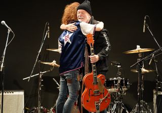Takeshi (left) and Randy Bachman embrace onstage in Tokyo, Japan on July 1, 2022