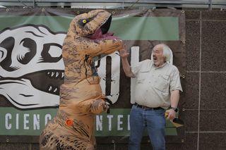 Jack Horner laughs next to a guest "dinosaur" at the Liberty Science Center.