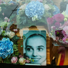A photograph taken on August 8, 2023 shows the coffin and a picture of late Irish singer Sinead O'Connor, in the hearse during her funeral procession outside her former home in Bray, eastern Ireland, ahead of her funeral on August 8, 2023. A funeral service for Sinead O'Connor, the outspoken singer who rose to international fame in the 1990s, is to be held on Tuesday in the Irish seaside town of Bray.