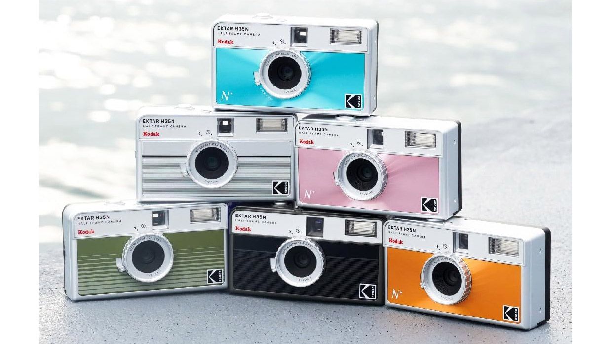 A lifestyle picture of six Kodak Ektar H35N cameras stacked up like a pyramid and each in different colors