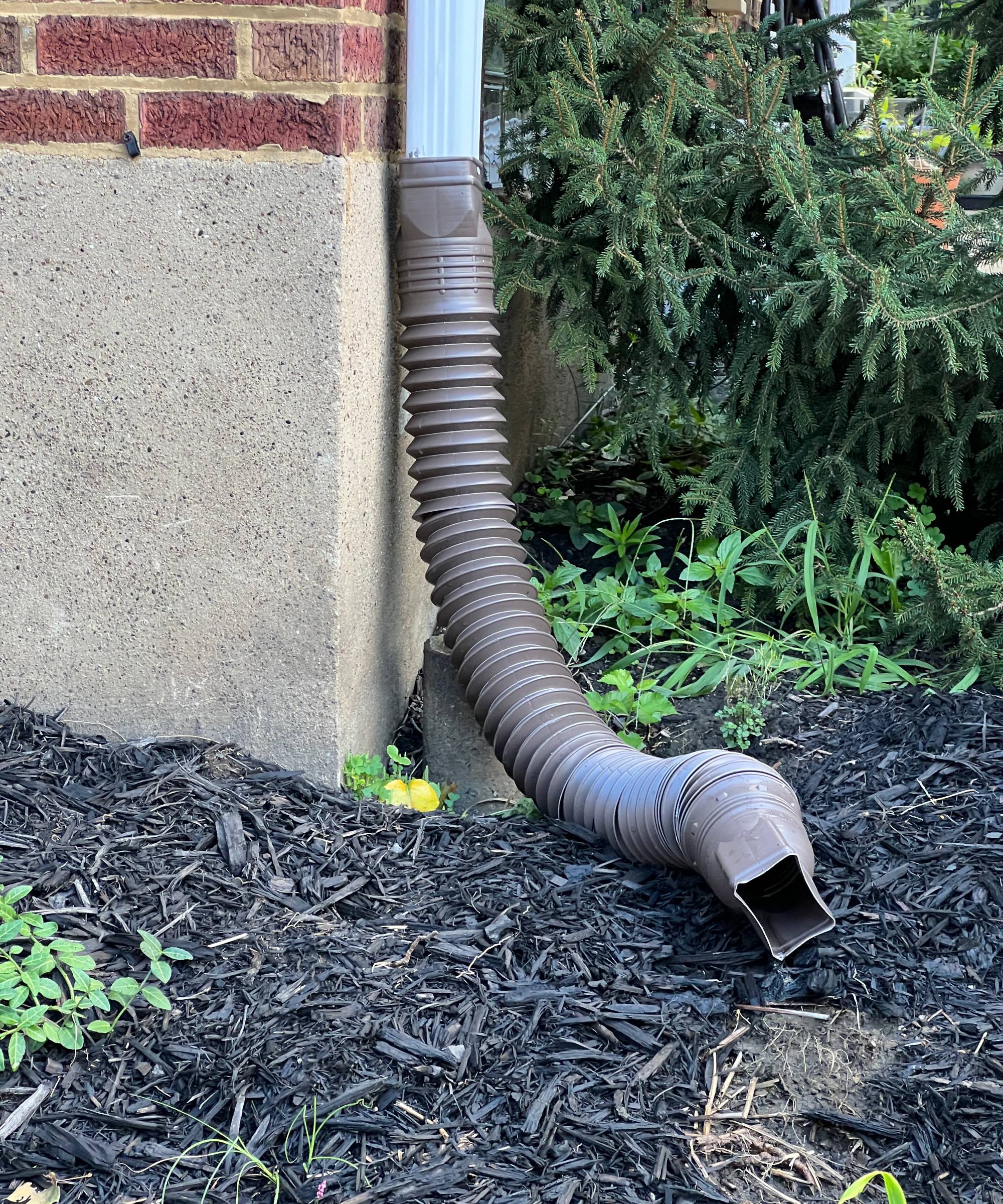 Downspout extension tube near building