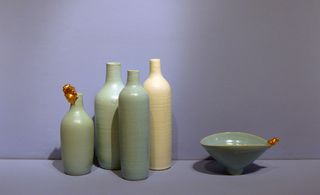 View of green and cream coloured ceramic vessels by Jang Jin against a purple and blueish coloured background