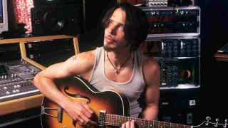 Chris Cornell playing the guitar in a recording studio