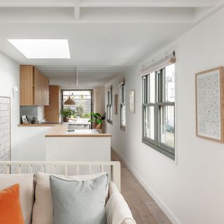 open plan living space with white couch and grey framed sash windows