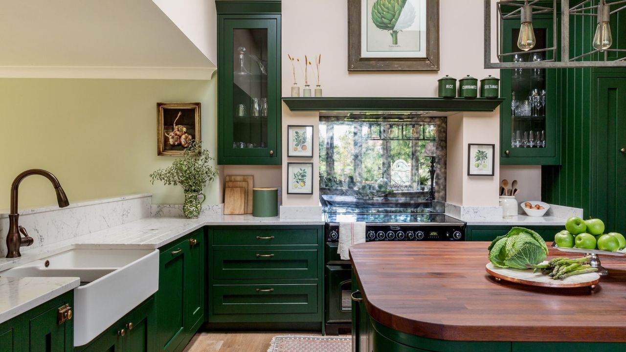 kitchen with dark green cabinets, wooden island, light pink walls