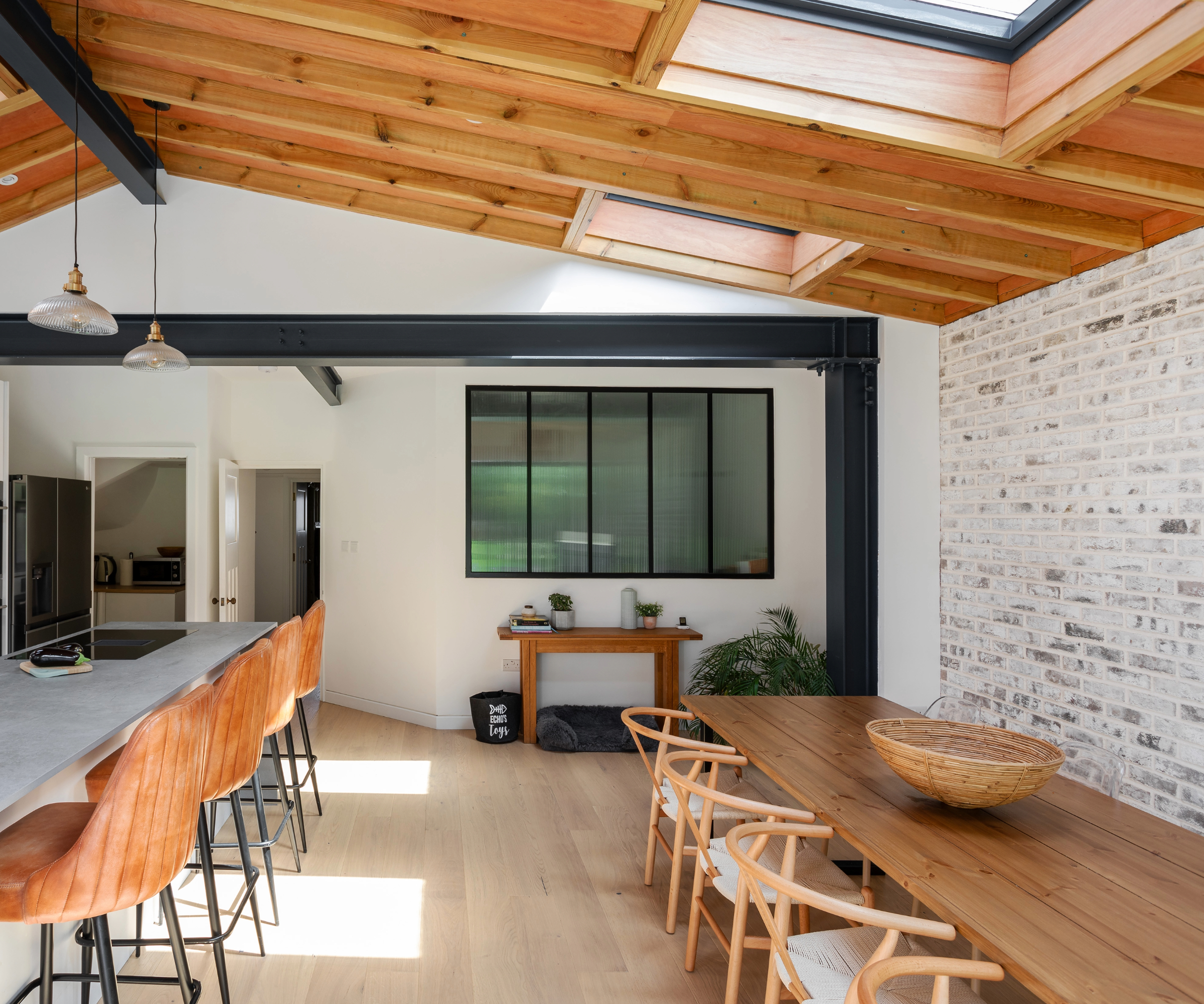 Wide shot of the dining area to the right and kitchen island to the left