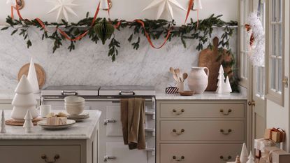A rustic kitchen decorated for Christmas with traditional garlands