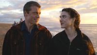 Gabriel Basso and Margaret Qualley as Charlie and Maya looking at each other while walking on the beach in Love Of Your Life