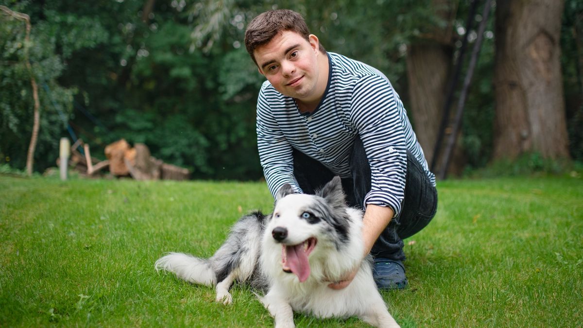 Man with Down syndrome playing outside with dog 