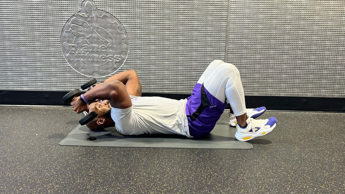 Teddy Savage completing a dumbbell floor chest press to triceps skull crusher