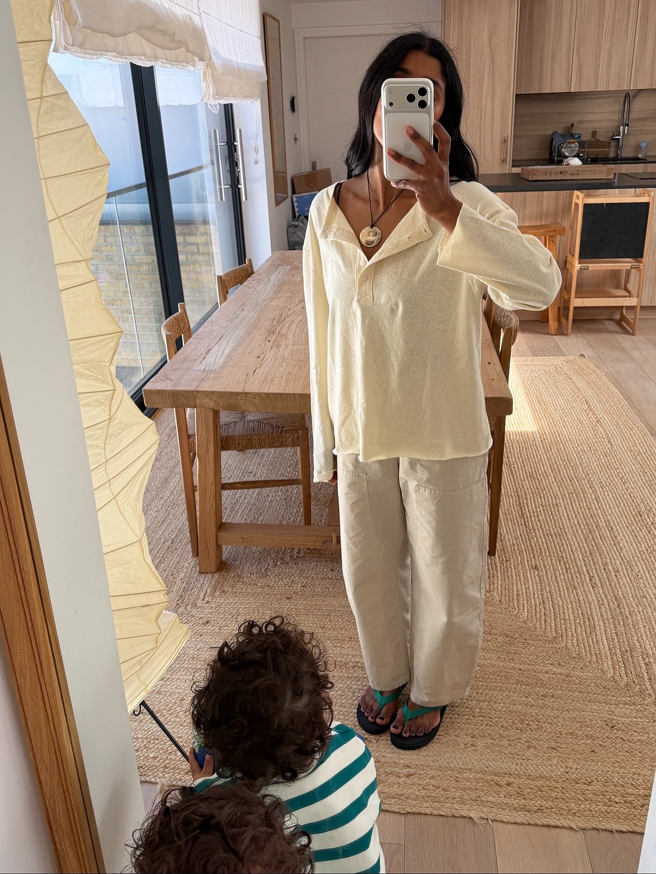 Monikh wears a henley shirt with cargo pants and flip-flops