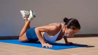 a woman doing a push up on her knees