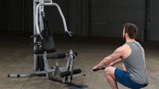 Body Solid Powerline BSG10X review: A man performs an arm row exercise using Body Solid's weights machine