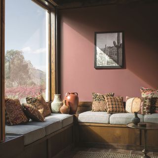 A red living room with brown accessories and a large window