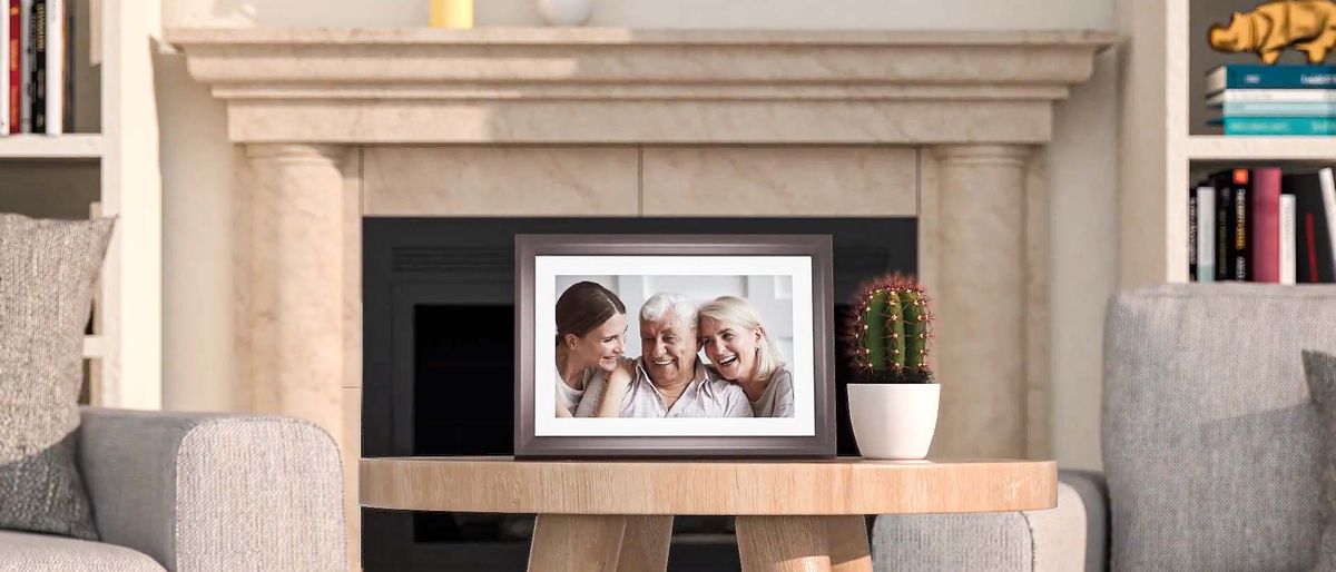 Dragon Touch Classic 10 Digital Picture Frame displaying a family while sitting on a living room table