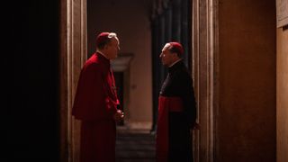 Two cardinals talking in a hallway