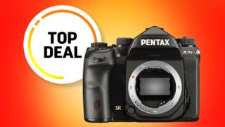 A Pentax K-1 II DSLR camera is featured against a vibrant orange background, highlighted by a "Top Deal" badge