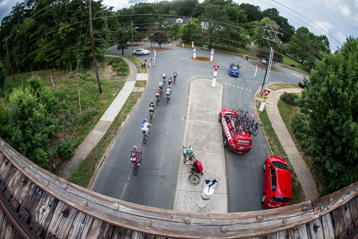 A rider gets a new wheel as the race passes by.