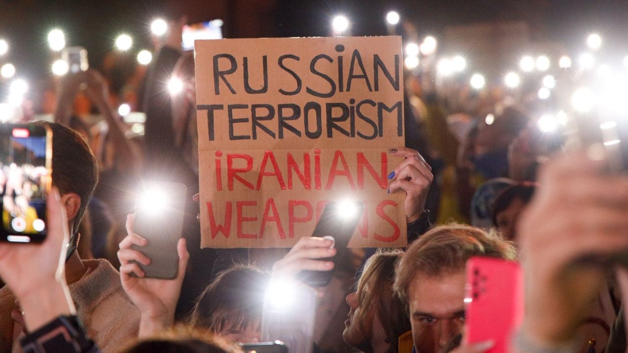 Protesters hold up their phones during a protest in Warsaw