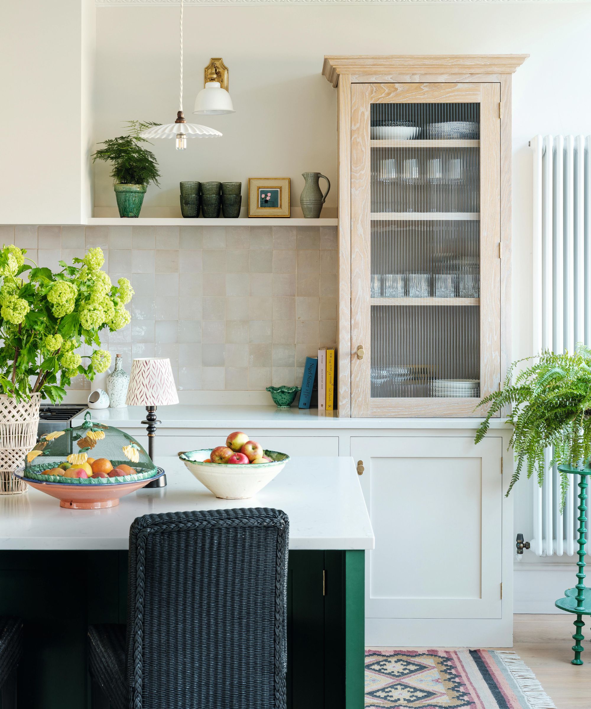 a neutral soft kitchen with zellige tiles, wooden countertop cupboard open shelving and a green island