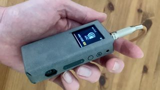 Fiio BTR7 in a hand on wooden background