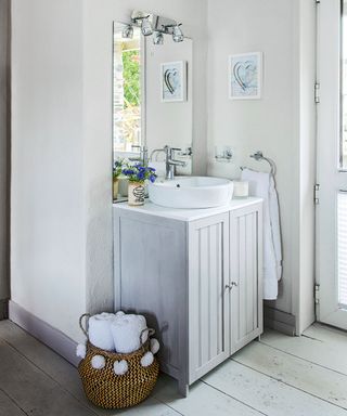 bathroom with wooden flooring and cabinet washbasin