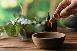 Essential oils for stress: A woman pouring an essential oil