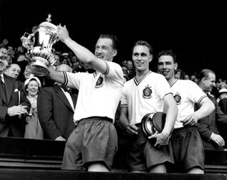 Bolton captain Nat Lofthouse lifts the FA Cup after victory over Manchester United in the 1958 final at Wembley